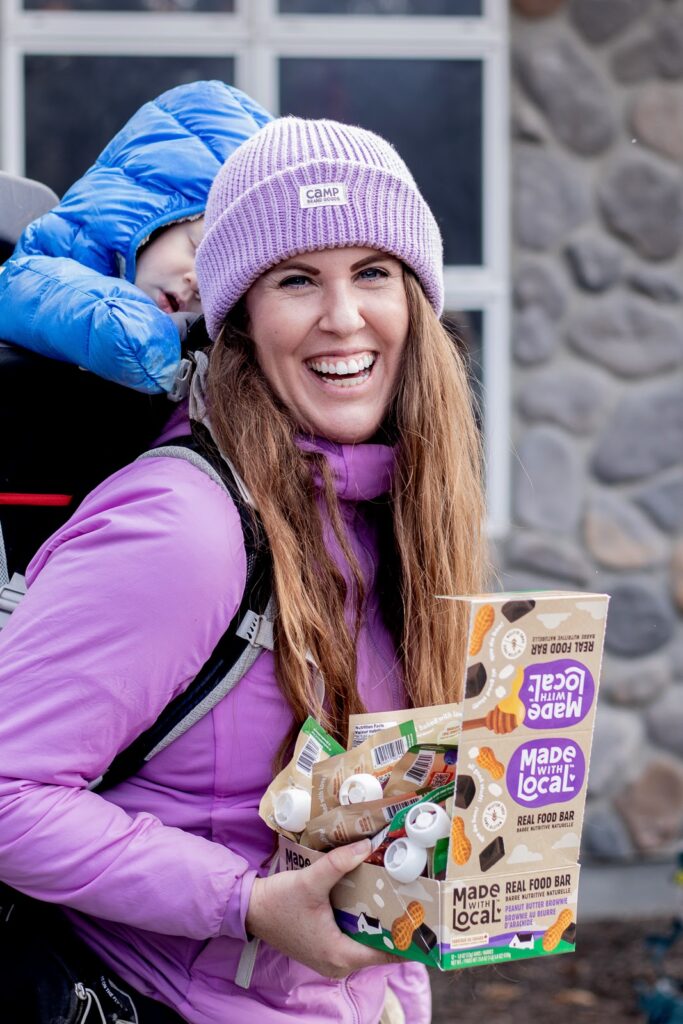 Adrianna holds snacks preparing for a cold-weather hike with kids.
