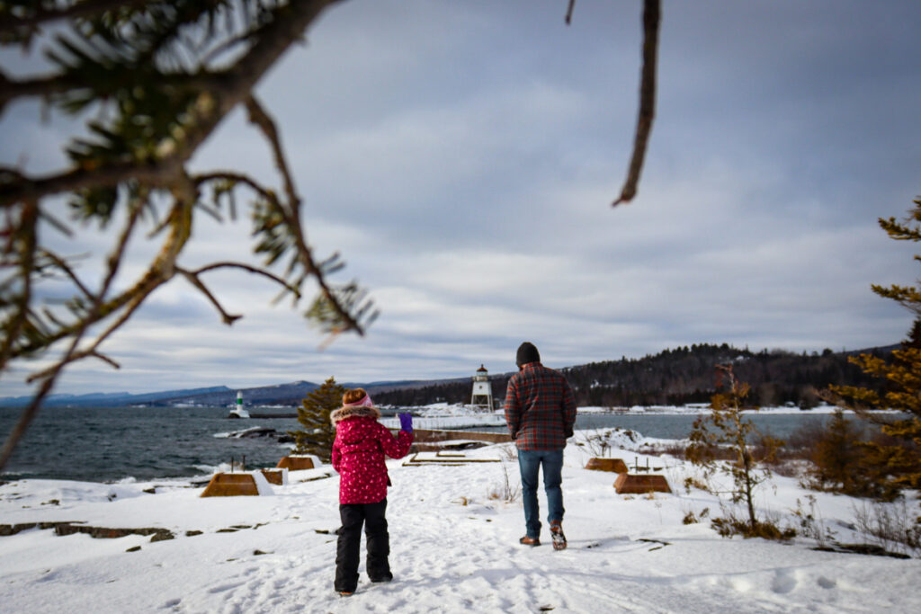 A dad and his young daughter enjoy Grand Marais in the snow.