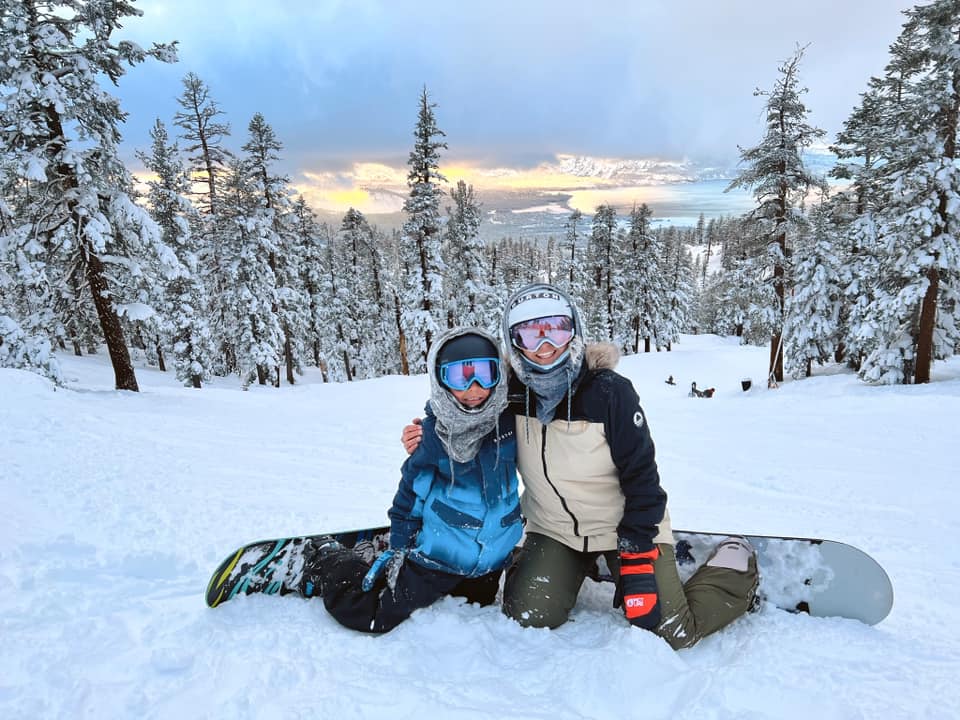 A mom and her young son snowboard in Lake Tahoe., one of the best winter vacations for families.