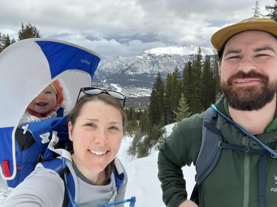 A family of three enjoys a winter hike in Canmore, one of the best winter vacations for families.