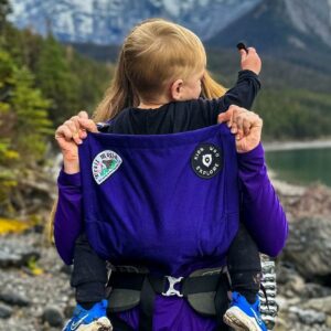 A young child in a KWE/Trail Magik collaboration carrier.