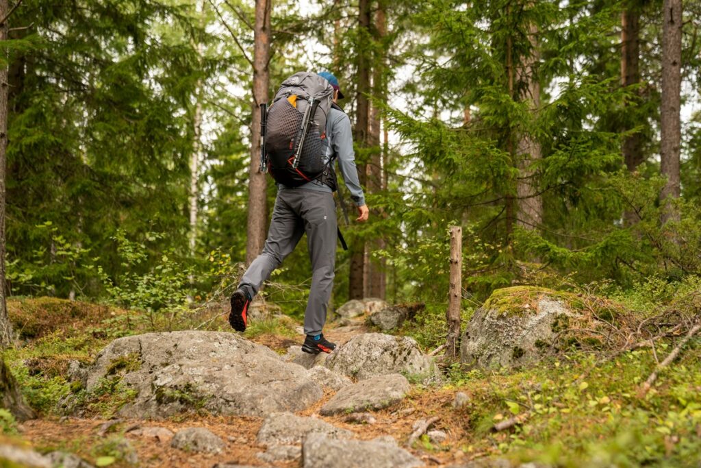 A hiker walks across a rocky path in Finland, one of the best places to visit in Europe with kids.