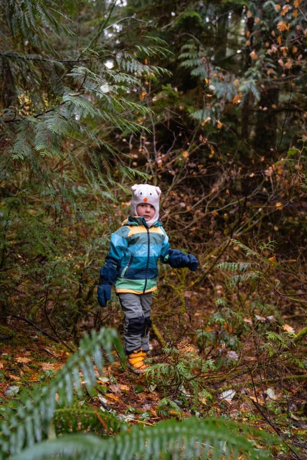 A young boy hikes in the rain.